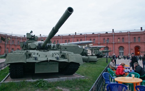 People eat next to a Soviet T-80 tank.